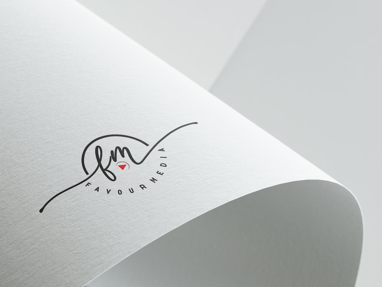 Minimalist design showcasing Favour Media logo on folded textured paper with copyspace.